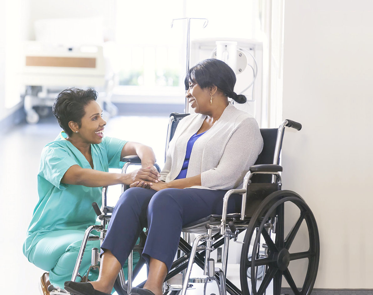 senior woman on a wheelchair talking to her caregiver